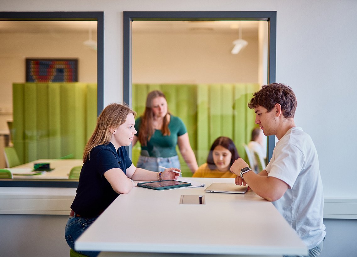 Eine Gruppe Studierender lernt gemeinsam in einem Lernraum der Uni